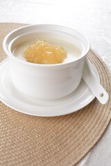 luxury chilled sweet fresh bird nest soup with almond paste and peach resin in bowl and pink table cloth halal healthy dessert menu
