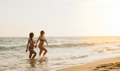 Gay women are holding hands and coming out of the sea