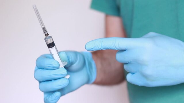 doctor with syringe blue gloves