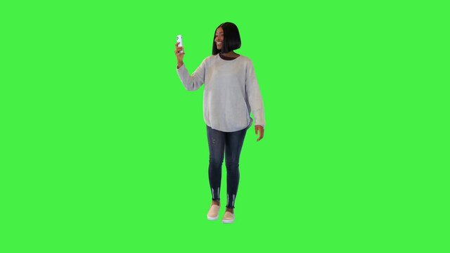 Joyful african american girl tourist walk with smartphone make photos for blog social media sharing on a Green Screen, Chroma Key.