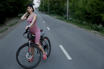 Fototapeta na wymiar The girl cyclist is engaged in sports, the concept of a healthy lifestyle