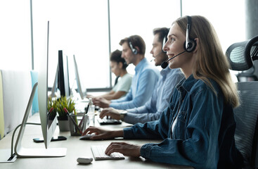 How can I help you? Beautiful call center workers in headphones are working at modern office