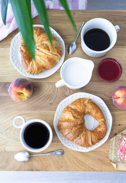 Breakfast with croissants, coffee and fresh fruit. Weekend breakfast. Breakfast and reading on Saturday morning. Lifestyle photography