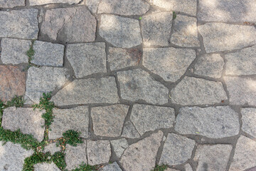 Stone paving stones on the sidewalk old road made of stone