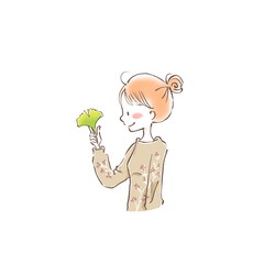 a young woman holding a autumn leave between her fingers