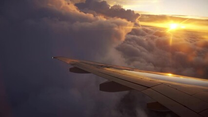 Aerial view of sunrise through airliner window in the morning. Aerial view of Cloudscape in dawn through plane window. Beautiful trip and good transportation with the plane concept.