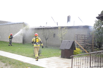 strażacy gaszą pożar budynku