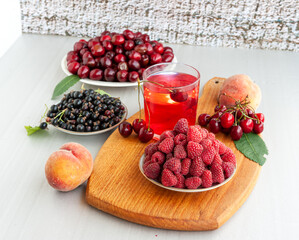 Summer gifts. Raspberries, peaches, black currants, cherries and red compote.