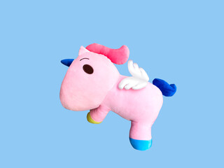 pink cute unicorn doll for child, pony on blue background,