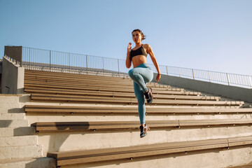 Young fitness woman exercising and stretching outdoors in the morning. Fit healthy athlete is doing...