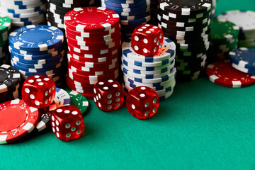 Pile of Casino pocker gambling chips and dices on green table