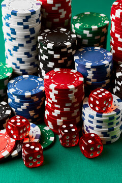 Pile of Casino pocker gambling chips and dices on green table