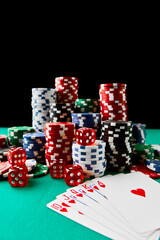 Casino chips, playing cards and dices on green fabric table