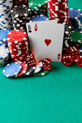 Casino chips, playing cards and dices on green fabric table
