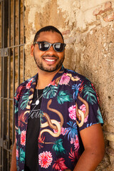 A black man walks through the streets of Cádiz with a colored shirt
