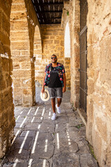 Fototapeta na wymiar A black man walks through the streets of Cádiz with a colored shirt