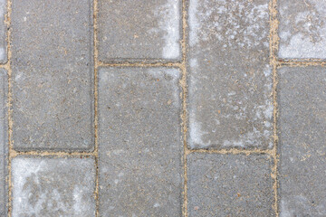 Gray texture of paving stones. Close-up of stone tiles for sidewalks. Top view