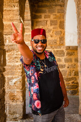 A black man walks through the streets of Cádiz with a colored shirt