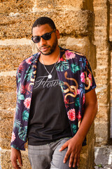 A black man walks through the streets of Cádiz with a colored shirt