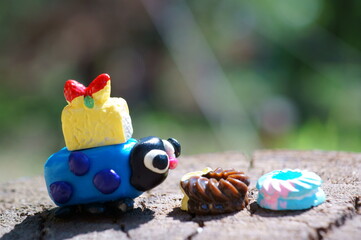 A figurine of a ladybug made of plasticine with cakes. Close-up. Summer harvesting.