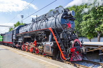 Black retro steam locomotive on the railway platform of the Rizhsky station. Moscow, Russia