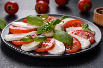 Italian caprese salad with sliced tomatoes, mozzarella cheese, basil, olive oil