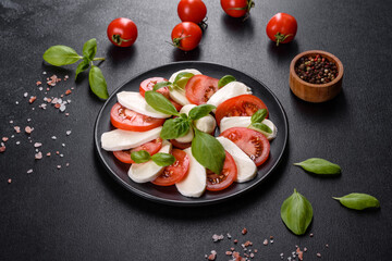 Italian caprese salad with sliced tomatoes, mozzarella cheese, basil, olive oil