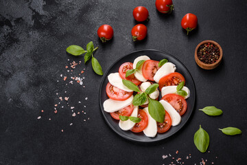Italian caprese salad with sliced tomatoes, mozzarella cheese, basil, olive oil