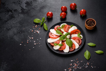 Italian caprese salad with sliced tomatoes, mozzarella cheese, basil, olive oil