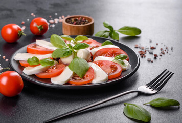 Italian caprese salad with sliced tomatoes, mozzarella cheese, basil, olive oil