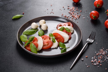 Italian caprese salad with sliced tomatoes, mozzarella cheese, basil, olive oil