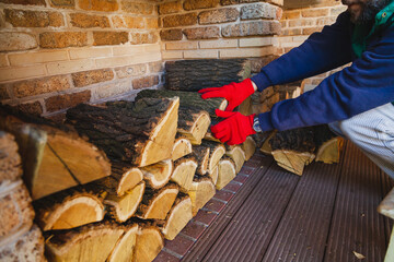 Gloved hands lay wooden log in niche