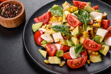 Delicious fresh salad with tomatoes, avocado, cheese and grilled corn with olive oil