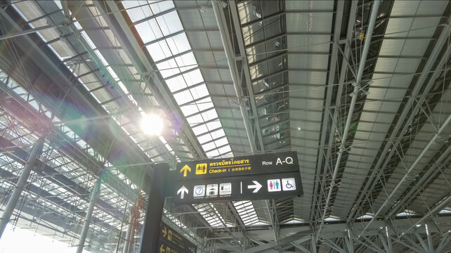 Abstract business background of Thailand international airport, the photo compose of the sign of check-in counter and tourist information in trilingual and structural roof with flare of sunlight.