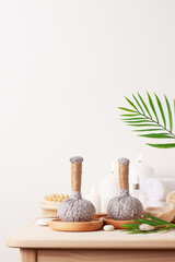 Spa treatment with herbal bags and candle on white background. Close up, copy space.