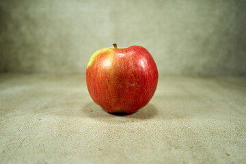 Red apple on the grey background in the photoshoot 