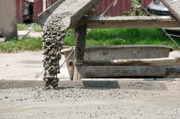 worker mixer cement truck machine pour fluid concrete into  floor house . Group of worker working...