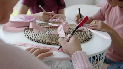 Group asia happy people senior mature lady and teen girl sit at home sofa write cheer up sign symbol quote on bow tied in program workshop class to help fight prevent female disease issue health care.