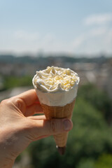 Sweet tasty ice cream corn with white chocolate in hand on a hot sunny day in summer