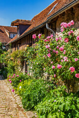 Gerberoy, Façade de maison couverte de roses dans une rue piétonne du village. Picardie....