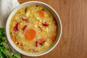 homemade vegetarian vegetable soup with bulgur and corn in a ceramic bowl, vegan lifestyle concept, flat lay, top view