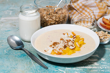 healthy smoothie bowl with mango, coconut and nuts