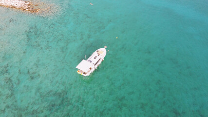 Drone view of boat anchored in beautiful, shallow turquoise Adriatic sea at the Rogoznica, small fishing village in dalmatian region of Croatia