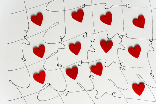 small red hearts and cursive script with the word love hand written multiple times on ivory paper 