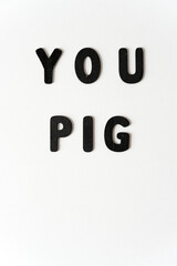 expression, you pig, in black chalk letters on a white background