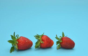 Fresh red strawberries on a blue background.