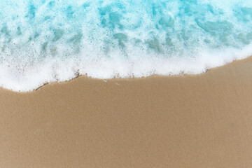 Blue ocean waves with white foam crashing on summer sand beach island top view with copy space, beautiful natural scene of tropical sand beach background.