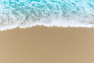 Fototapeta na wymiar Blue ocean waves with white foam crashing on summer sand beach island top view with copy space, beautiful natural scene of tropical sand beach background.