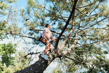 Teenage girl climbing a tree and feeling relaxed