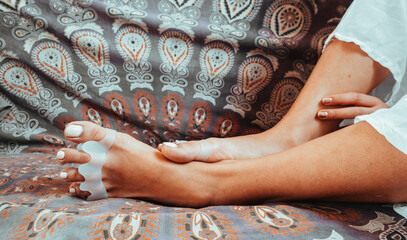Closeup shot of a female wearing toe separators relaxing at home